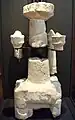 Plusieurs morceaux assemblés d'une sculpture avec trois piliers apparents.