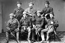 Photo en noir et blanc d'un groupe de paléontologues armées de fusils