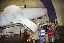 L'astronome Jean Mueller posant avec le télescope de Schmidt Samuel-Oschin.