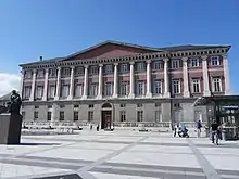 Photographie en couleur d'une place publique avec un bâtiment.