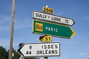 Deux panneaux D21a et un ancien panneau d'itinéraire bis.