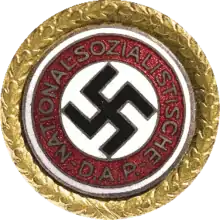 Une croix gammée entourée d'un insigne circulaire doré.