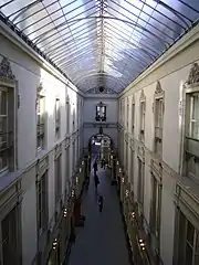 La galerie (en enfilade entre deux façades blanches) et sa verrière, vues du second étage.