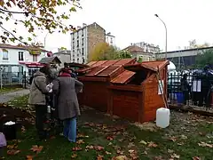 Pavillon de compostage de quartier du Square de la Place de la République à Montreuil (Seine-Saint-Denis), inauguré le 26 novembre 2011, avec l'association « Le Sens de l'Humus ». Deux compartiments (1,7&nbsp;m3 chacun) pour les résidus végétaux et un compartiment de réserve (1&nbsp;m3) contenant du bois raméal fragmenté et un réservoir de récupération de l'eau de ruissèlement. Bois de récupération (palettes). Éléments démontables. Réalisé par des Roms dans le cadre d'un projet d'insertion. Financement : ville de Montreuil. Photographie : ville de Montreuil (cliquez sur l'image).