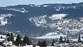 Paysage hivernal à Villers-le-Lac. L'église Saint-Jean (XIXe&nbsp;siècle), le lac de Chaillexon (partiellement recouvert de glace) et Les Brenets (Suisse).