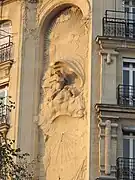 Décor Art Nouveau pour un cadran solaire sur la hauteur de 4 étages d'un immeuble rue Perrée à Paris (3eme arr) : en haut une femme représente l'aurore et en bas, le soir est figuré par une femme dont le visage est caché par un voile.