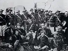 Photographie d'un groupe d'hommes en uniformes militaires avec des chapeaux mous