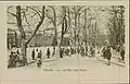 Photo de la promenade est de la place datant du 20e siècle, On voit à l'image des gens marchant ou discutant sous une allée de platanes et sur un sol fait de terre et de petits gravier. À l'arrière-plan, derrière les platanes, on aperçoit le centre de la place et la rangée d'immeubles bordant celle-ci.