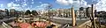 Vue panoramique d'une partie de la place Jean-Jaurès depuis le haut des jeux du parc pour enfants au cœur de la place. Des gens s'amusent, d'autres passent en marchant, un pigeon nous regarde du haut de son perchoir.