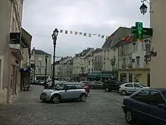 Photographie de la place du marché, l'ancienne mairie était située dans le premier bâtiment à gauche.