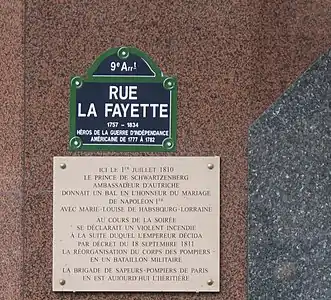 Plaque de rue sous laquelle une plaque commémorative rappelle l’origine de l’organisation militaire de la brigade des sapeurs-pompiers de Paris.