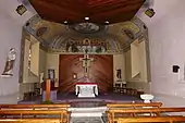 Photographie couleur de l'intérieur d'une église à nef unique de petites dimensions.