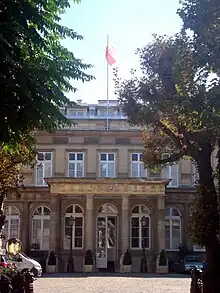 Photo en couleur d'une partie de façade avant d'un hôtel particulier avec son péristyle.