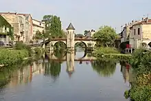 Photographie d'une rivière avec un pont en arrière-plan.