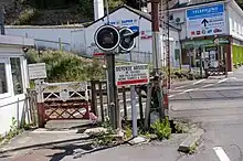 détail du passage à niveau manuel avec le portillon les panneaux d'avertissements et les feux