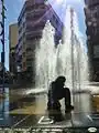 La Fontaine des Enfants avec les bâtiments de la place en arrière-plan