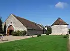Photographie en couleurs d'un bâtiment agricole et d'un pigeonnier