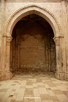 Arc ogival bordé d'un cordon de bâtons brisés.