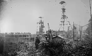 Un petit groupe de personnes avec des silhouettes floues d'installations industrielles en arrière-plan.