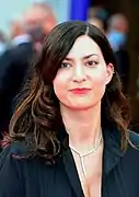 Photographie d'une femme brune souriante.