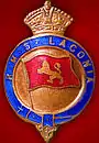 Insigne comportant le texte « R.M.S. LACONIA », un drapeau avec un lion ou un léopard sur fond rouge, et une couronne surmontant l'ensemble.