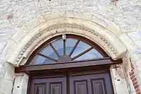 La porte moulurée en plein cintre qui date du XIIe&nbsp;siècle est la partie la plus ancienne de l'église.