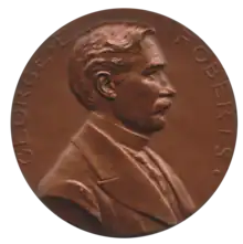 Médaille de couleur bronze, montrant le buste de profil d'un homme moustachu au cheveux courts et comprenant l'inscription George E. Roberts.