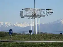 Photographie en couleurs d'un rond-point, avec la reproduction d'un ancien avion.