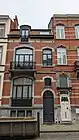 Au no&nbsp;11 : maison éclectique de deux niveaux de composition asymétrique, sous mansarde, architecte Fernand Conard, 1910. Façade de briques rouges, rehaussée de briques blanches et de pierre bleue.