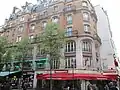Immeuble de l'angle de la rue Saint-Denis (no&nbsp;30), avec la statue d'Eugène Scribe.