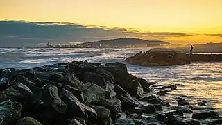 Coucher de Soleil sur la plage de Frontignan en regardant vers Sète. Le mont Saint-Clair se détache dans la langue de nuages.  Février 2023.