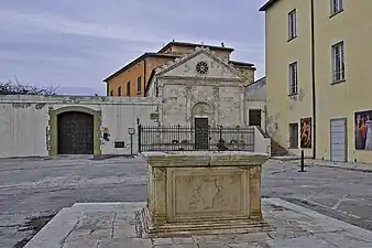 La citerne au milieu de la place et la chapelle.