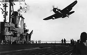 SB2C-4E de la VT-74 au-dessus de l'USS&nbsp;Midway&nbsp;(CV-41). Le pod radar APS-4 est visible sous l'aile (1946).