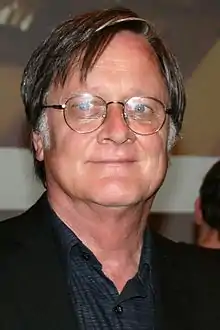 Homme avec des yeux bleus et des lunettes.