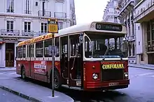 Photographie en couleurs de trois quarts d'un autobus rouge et blanc.