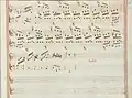 partition manuscrite rehaussée de couleurs passées rouge et vert en bordures