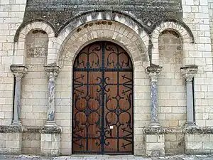 Le portail avec des colonnes et des chapiteaux pouvant provenir de la basilique mérovingienne.