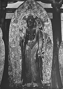 Yakushi Nyorai, dit Shaka Nyorai debout. Fin IXe&nbsp;siècle. Bois peint, H. 2,38&nbsp;m. Murō-ji, Nara.