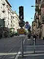 Image représentant un feu tricolore de tramway avec la barre verticale marquant le passage autorisé allumée, ainsi que la vitesse limitée à 30&nbsp;km/h à la station Palais des expositions.