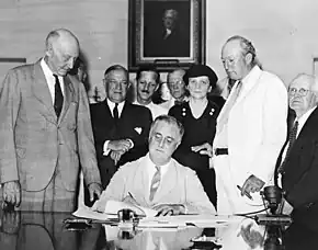 Frances Perkins à la signature par le président Franklin Roosevelt de la création d'une sécurité sociale.