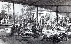Gravure représentant une large étable sans murs avec des hommes torses nus rassemblés autour d'un chaudron au premier plan. D'autres personnages sont engagés dans diverses activités à l'arrière-plan et des cavaliers entrent dans le bâtiment sur la gauche de l'image.