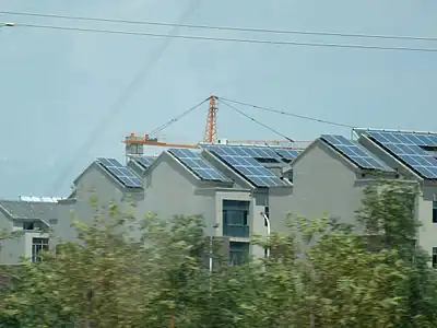 Habitats urbains en construction, les toits sont tapissés de panneaux solaires photovoltaïques, banlieue de Tourfan. Juillet 2012.
