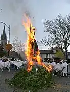 Le mannequin en paille brûle sur un bûcher, autour duquel des Soufflaculs dansent en formant un cercle.