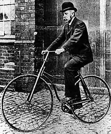 Photo ancienne en noir et blanc d'un homme à vélo.