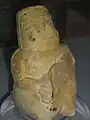 Idole de couleur ocre avec un morceau brisé qui devait être un enfant.