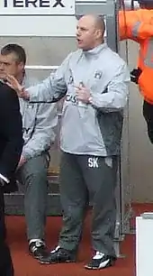 un entraîneur de football sur un banc de touche