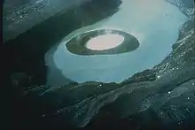 Vue aérienne de l'intérieur de la caldeira de Volcano Island en 1965 avec un cône de cendre, aujourd'hui détruit, dans le lac.