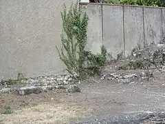 Photographie en couleurs d'un mur ruiné pour vu deux décrochements.
