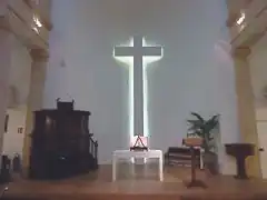 Intérieur du temple, chaire, table, bible, baptistère et croix.