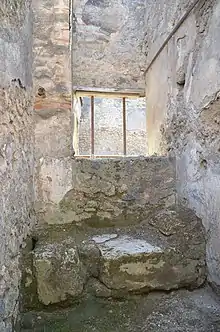 Pièce avec sur le bas une banquette en maçonnerie surplombée d'une fenêtre.